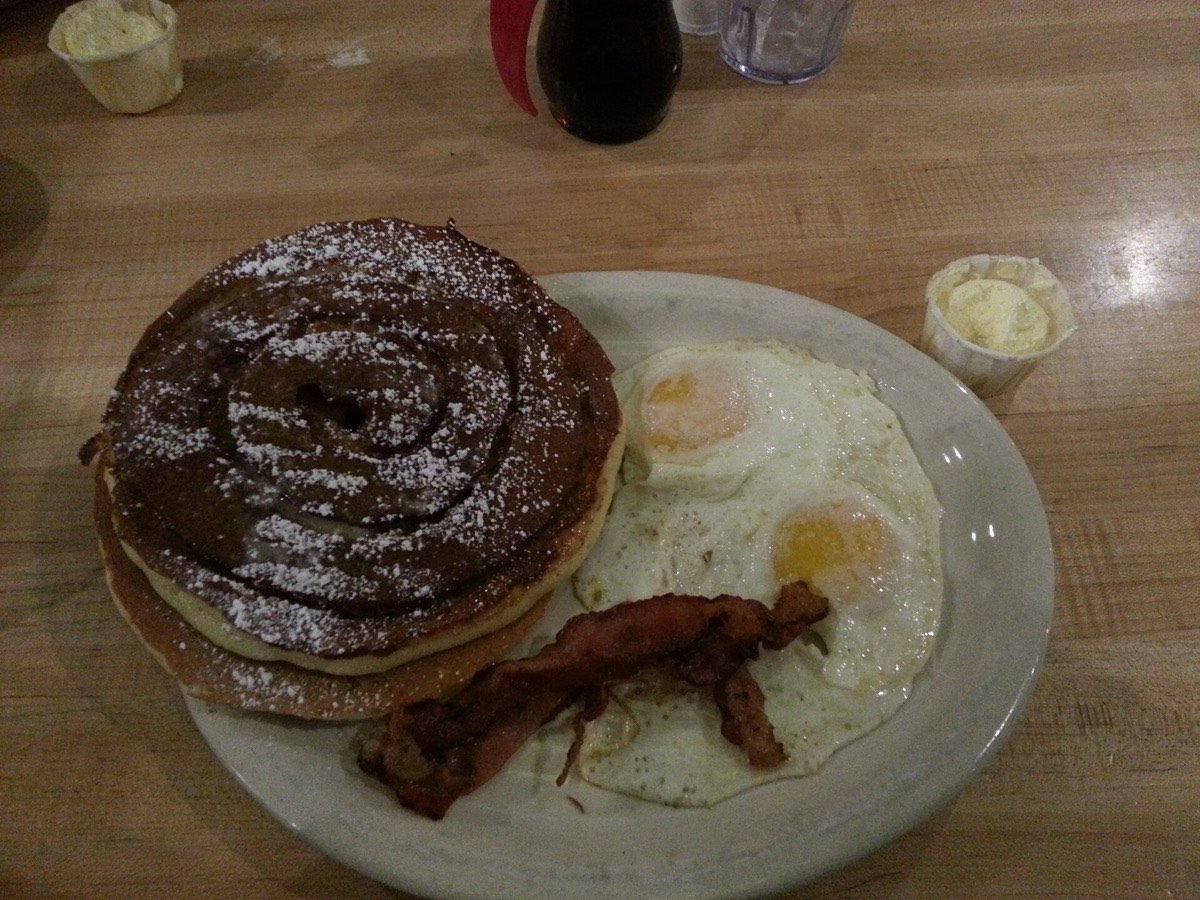 Diner breakfast of pancakes, bacon, and eggs