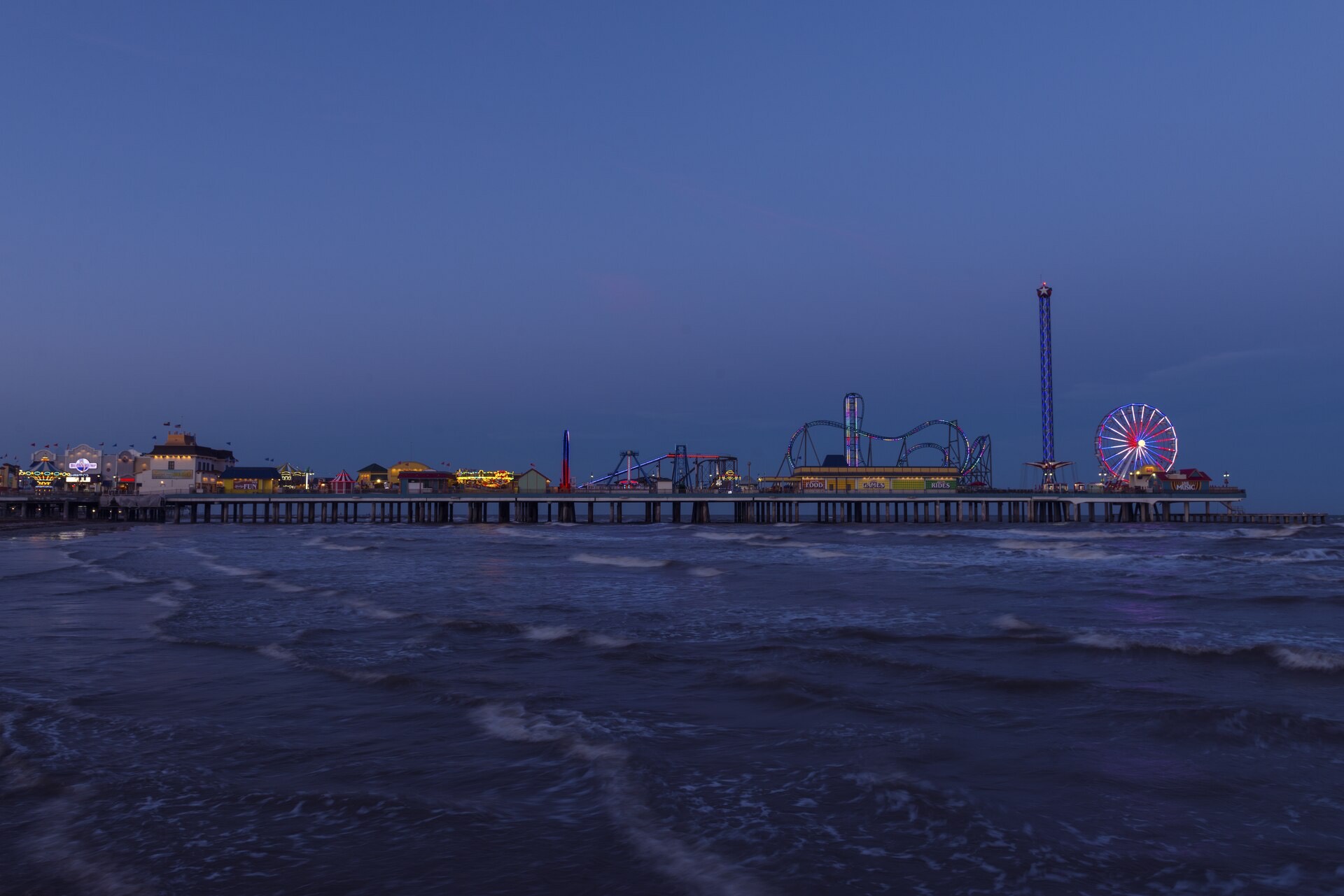 Pleasure Pier lit up at dusk over the Gulf of Mexico in Galveston