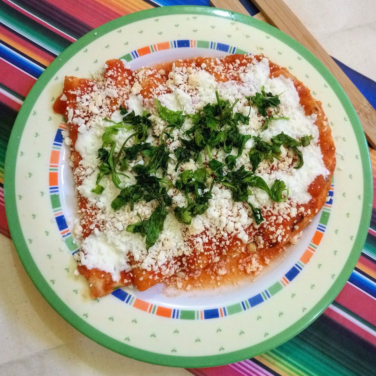 Enchiladas plated with red salsa